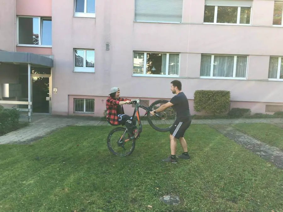 Bruder von Fabienne Tanner hilft beim Üben eines Wheelies mit dem Mountainbike